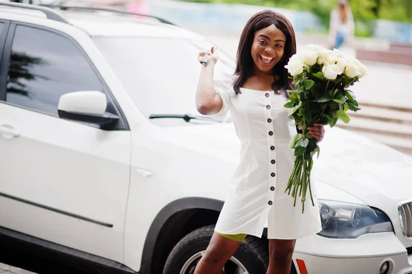 在城市里约会时 美丽的非洲裔美国女孩手持一束白玫瑰花 开着一束花的黑人女商人拿着她那辆新车的钥匙 — 图库照片