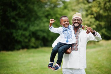Afrikalı baba ve oğlu parkta geleneksel giysiler içinde.. 