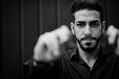 Orta Doğulu girişimci mavi gömlek giyer, çelik duvara karşı gözlük takar..