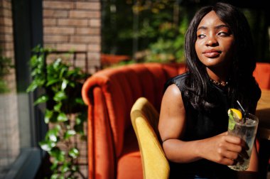 Restorandaki Afrikalı Amerikalı kadın limonata içiyor..