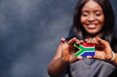 Afrikalı kadınlar küçük Güney Afrika bayrağını ellerinde tutuyorlar.