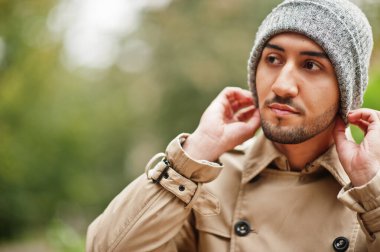 Trençkot ve şapkalı şık bir Kuveytli..