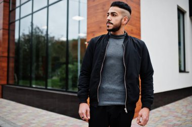 Tarz sahibi Arap sakallı adamın portresi gri balıkçı yaka ve siyah jaket giyiyor. Arap model adam..