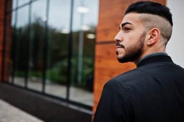 Tarz sahibi Arap sakallı adamın portresi gri balıkçı yaka ve siyah jaket giyiyor. Arap model adam..