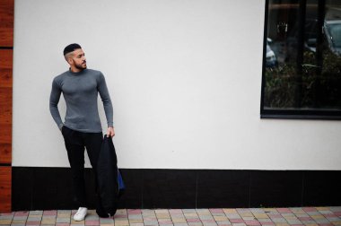 Tarz sahibi Arap sakallı adamın portresi gri balıkçı yaka ve siyah jaket giyiyor. Arap model adam..