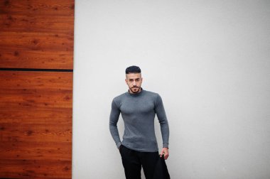 Tarz sahibi Arap sakallı adamın portresi gri balıkçı yaka ve siyah jaket giyiyor. Arap model adam..