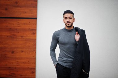 Tarz sahibi Arap sakallı adamın portresi gri balıkçı yaka ve siyah jaket giyiyor. Arap model adam..