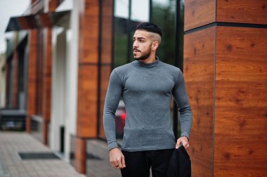 Tarz sahibi Arap sakallı adamın portresi gri balıkçı yaka ve siyah jaket giyiyor. Arap model adam..