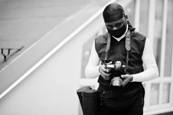 プロ仕様のカメラをプロ仕様のアフリカ系アメリカ人の若手映像作家 黒いデュラックと顔の保護マスクを身に着けているアフロカメラマン ビデオを作る — ストック写真