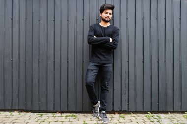 Şehirli genç hippi Hintli adam tamamen siyah giyer. Havalı Güney Asyalı adam..