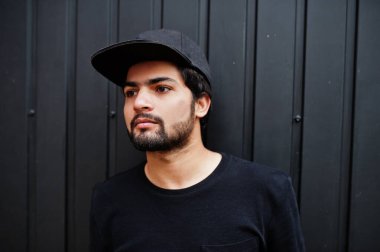 Şehirli genç hippi Hintli adam tamamen siyah giyer. Tam şapkalı havalı Güney Asyalı adam..