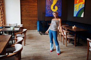 Cafe 'de leopar desenli rasta giymiş güzel Afrikalı Amerikalı kadın. Güzel, havalı, modaya uygun, siyah, genç bir kız..