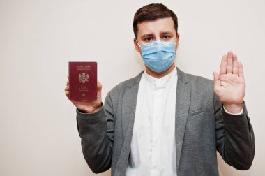 Resmi giysili ve maskeli Avrupalı bir adam dur işareti elli AAA pasaportu göstersin. Avrupa ülke konseptinde Coronavirus tecrit. 