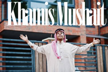 Khamis Mushait - Suudi Arabistan 'ın en büyük şehri. Orta Doğu Suudi Arabistan 'lı adam ellerini havaya kaldırarak modern yapıya karşı caddede poz verdi.