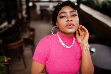 Pembe bluzlu Afro-Amerikan kadın. Burnunda piercing olan afro moda şık kadınlar..