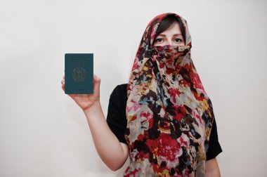 Türbanlı genç Arap kadın Afganistan İslam Cumhuriyeti pasaportunu beyaz duvar arkasında, stüdyo resminde tutuyor.. 