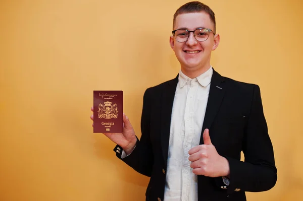 Joven Hombre Guapo Sosteniendo Georgia Pasaporte Sobre Fondo Amarillo Feliz — Foto de Stock