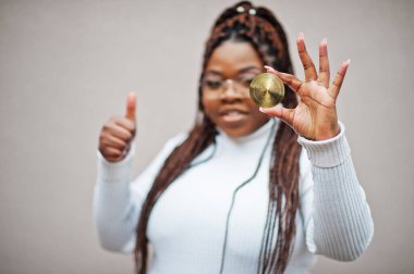 Afrikalı Amerikalı iş kadını yıldız parası ve baş parmağını kaldırdı. Kripto para birimi kavramı.