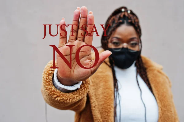 Just say no. African american woman, wear black face mask show stop hand sign.