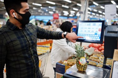Asyalı çift salgın sırasında süpermarkette koruyucu yüz maskesi alışverişinde birlikte takılıyor. Pineaple 'ı tart.