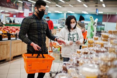Asyalı çift salgın sırasında süpermarkette koruyucu yüz maskesi takıyor..