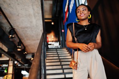 Kafede siyah bluzlu genç Afrikalı bir kadın var.. 