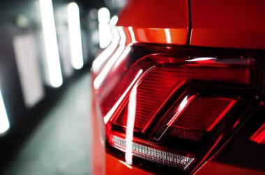 Modern garajda güzel ve yeni turuncu spor SUV arabasının stop lambası..