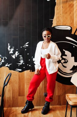 Kafedeki Afrikalı kadın bir fincan çayla.