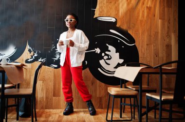 Kafedeki Afrikalı kadın bir fincan çayla.