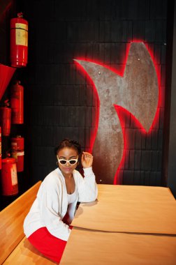 Afrikalı kadın duvara karşı eski bir yangın söndürücüyle poz vermiş..