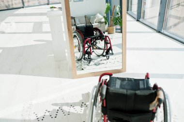 Evde boş tekerlekli sandalye var. Tekerlekli sandalye aynada..