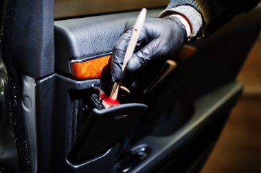 Üniformalı ve solunum cihazlı bir adam, araba yıkama merkezi çalışanı, araba temizleme fırçası. Araba temizleme kavramı.