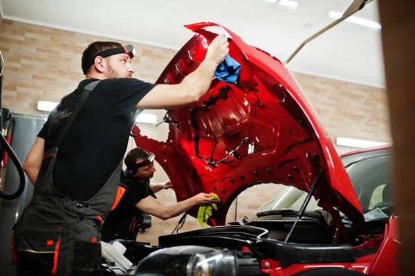 Araba Servisi Çalışanı Araba Tamirhanesindeki Kırmızı Bir Arabanın Üzerine Çakıl — Stok fotoğraf