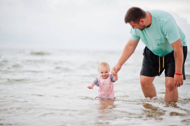 Yaz tatilleri. Ebeveynler ve insanlar çocuklarla birlikte dışarıda faaliyet gösteriyor. Mutlu aile tatilleri. Babası ve küçük kızı denizde..