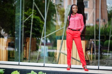 Pretty braids business african american lady bright bossy person friendly wear office red shirt and trousers. 
