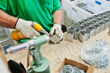 Erkek işçi tornavida makinesini tutar ve kullanır..