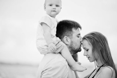 Yaz tatilleri. Ebeveynler ve insanlar çocuklarla birlikte dışarıda faaliyet gösteriyor. Mutlu aile tatilleri. Baba, hamile anne, küçük kız deniz kumsalında.. 