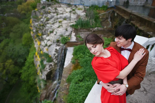 Young beautiful couple kiss near waterfall — Stock Photo, Image