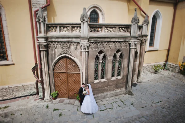 Svatební pár v blízkosti starého kostela — Stock fotografie