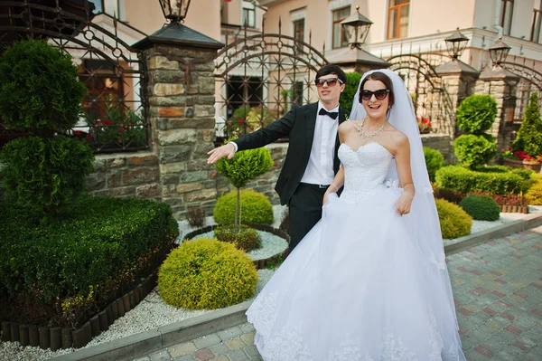 Unga vackra bröllopsparet med mörka glasögon — Stockfoto