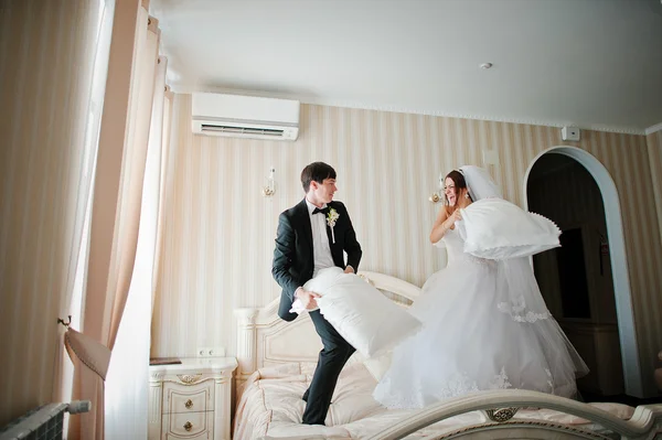 Casal bonito jovem no travesseiro da luta do quarto do hotel — Fotografia de Stock