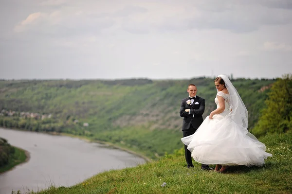 Bröllopsparet bo uppe på en kulle nära floden — Stockfoto