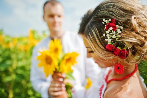 Wedding beautiful couple in traditional dress at the sunflower — Stock Photo, Image