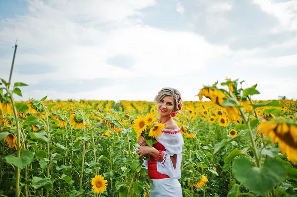 Beautiful bride in traditional dress at the sunflower — Stock Photo, Image