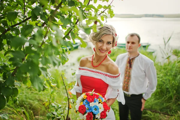 Wedding beautiful couple in traditional dress on the dock — Stock Photo, Image