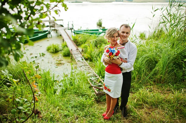 Wedding beautiful couple in traditional dress on the dock — Stock Photo, Image