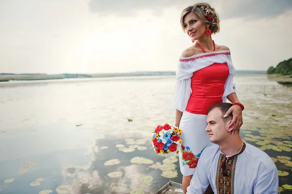 Wedding beautiful couple in traditional dress on the dock — Stock Photo, Image