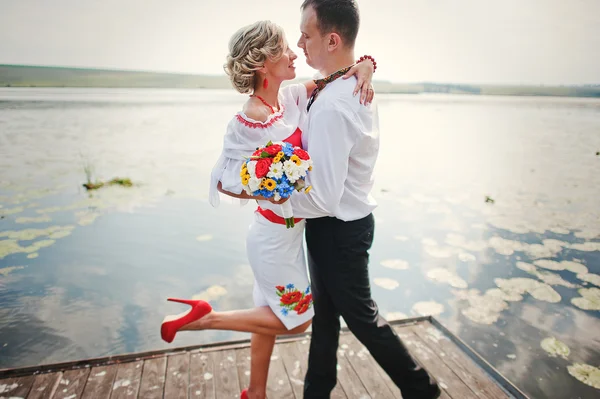 Wedding beautiful couple in traditional dress on the dock — Stock Photo, Image