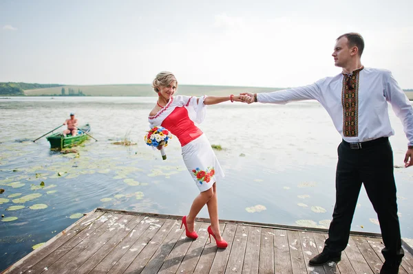 Casamento belo casal em vestido tradicional na doca — Fotografia de Stock