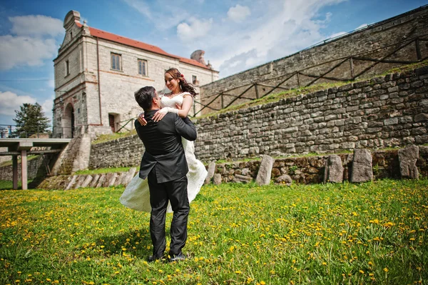 Wedding couple near old castle at the field of dandelions — Stock Photo, Image